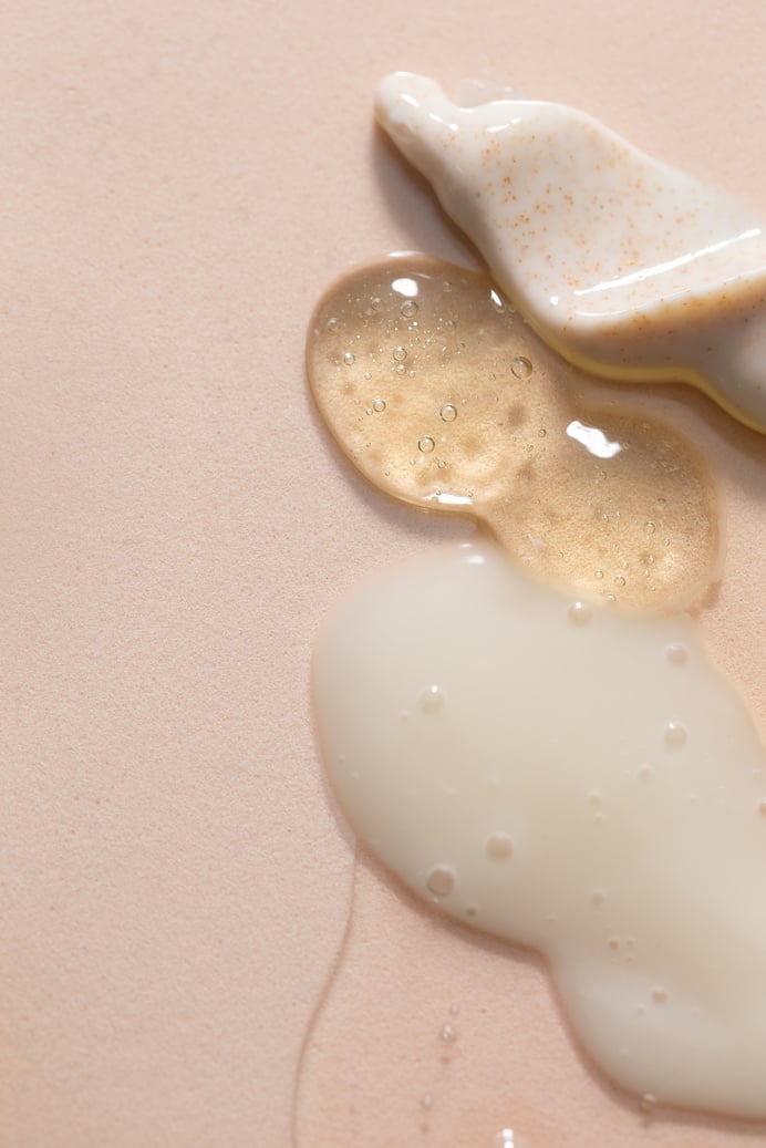 Assorted Liquid Skincare Products on Beige Background